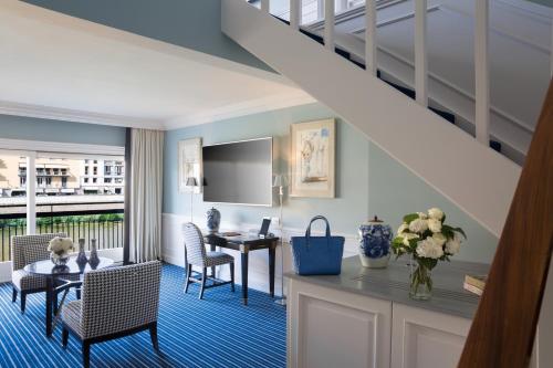 a living room with a table and chairs and a staircase at Hotel Lungarno - Lungarno Collection in Florence