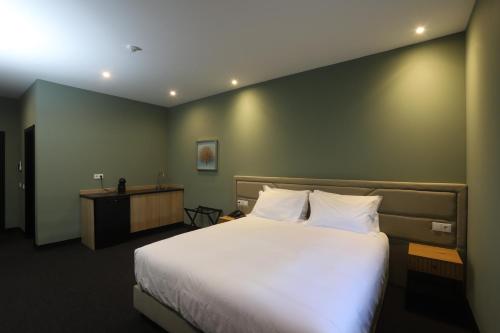 a bedroom with a large bed and a desk at Albufeira Lounge Hotel in Albufeira