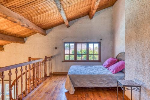 - une chambre avec un lit doté d'oreillers roses et d'une fenêtre dans l'établissement Villa Montady avec piscine, à Montady