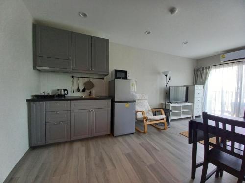 eine Küche mit einem Kühlschrank sowie einem Tisch und Stühlen in der Unterkunft G16 Title Naiyang 36м2Ватсап669З5В2I976 in Nai Yang Beach