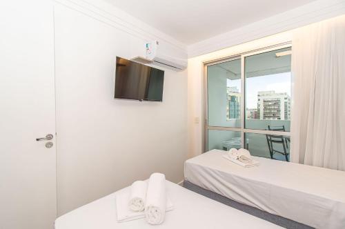 a white room with two beds and a window at BSB STAY Torre Flats Particulares - Mercure Líder in Brasilia