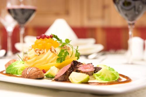 a plate of food with meat and vegetables on a table at Siebenschläfer Ferienwohnung in Neustift im Stubaital