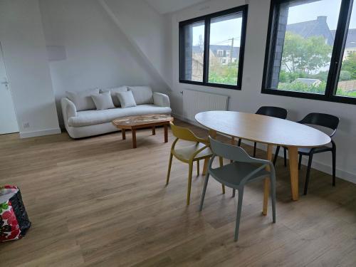 un salon avec une table, des chaises et un canapé dans l'établissement Appartement Ker Ty mor proche mer, à Port-Louis