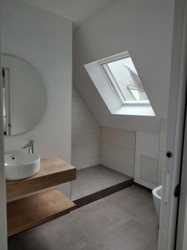 La salle de bains est pourvue d'un lavabo et d'une lucarne. dans l'établissement Appartement Ker Ty mor proche mer, à Port-Louis