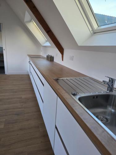 une cuisine avec un évier et une fenêtre dans l'établissement Appartement Ker Ty mor proche mer, à Port-Louis