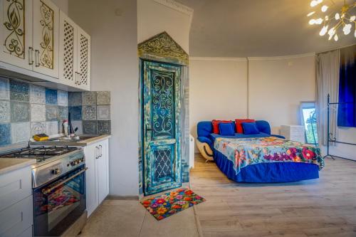 a bedroom with a bed and a kitchen with a stove at Batumi Wonderland in Batumi
