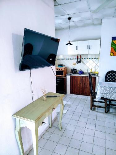 a living room with a table and a tv on the wall at A&C Temporarios in Corrientes