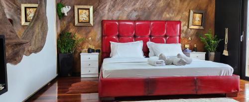 a red bed with two stuffed animals on it at Eye Luxury Penthouse in Sarandë