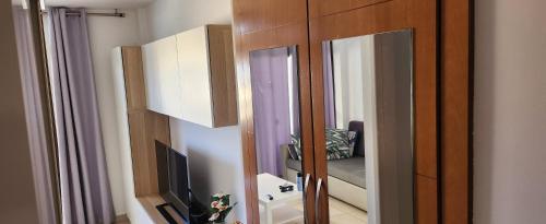 a room with a mirror and a tv and a bedroom at Playa del Ingles. Apartamento al lado del océano in San Bartolomé de Tirajana