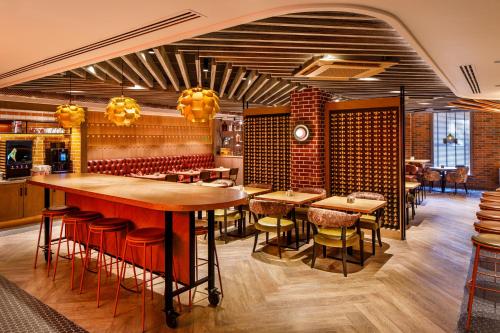 a restaurant with tables and chairs and a bar at ibis Styles York Centre in York