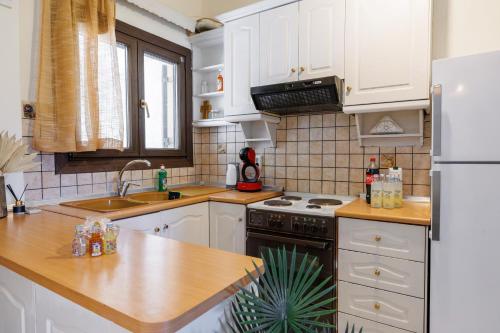 a kitchen with white cabinets and a stove top oven at Breathing Apartment in Virós