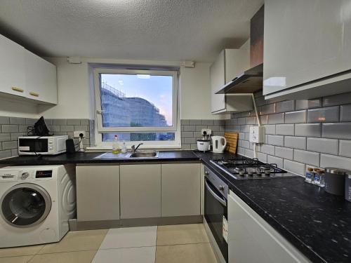a kitchen with a sink and a washing machine at Wapping Stay in London