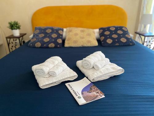 a bed with folded towels and a book on it at Casa Luca in Forza dʼAgro