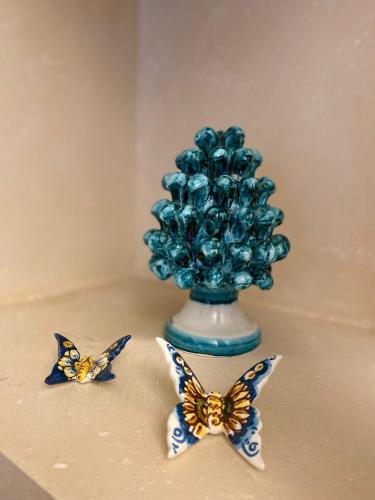 a blue vase with butterflies on a table at Casa Luca in Forza dʼAgro