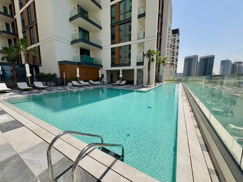 a swimming pool with chairs and a building at FIRST CLASS Studio Unwind in Style in Dubai