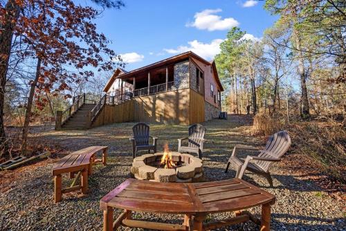 a fire pit in front of a log cabin at Twilight Pines - Dreamy Cabin w Hot Tub & optional Kids Loft in Broken Bow