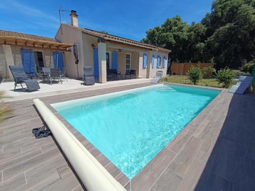 a swimming pool in front of a house at Maison Provençale - Piscine & Terrain de Pétanque in Grillon