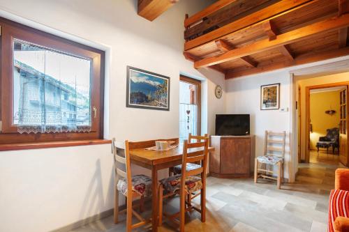 a dining room with a table and a television at La Vieille Cloche in Saint-Rhémy-en-bosses