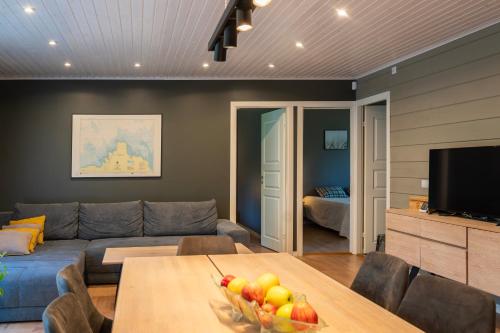 a living room with a couch and a table with a bowl of fruit at Jõeranna Lodge in Paope