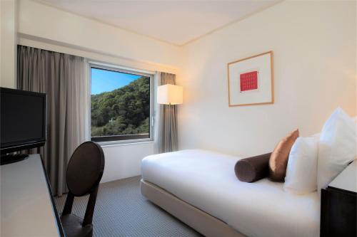 a hotel room with a bed and a window at ANA Crowne Plaza Kobe by IHG in Kobe