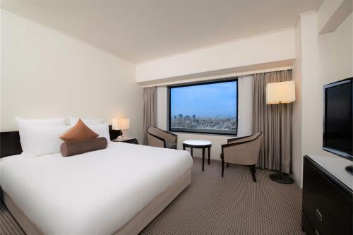 a hotel room with a large bed and a large window at ANA Crowne Plaza Kobe by IHG in Kobe