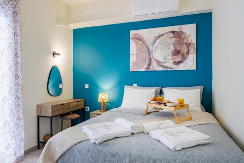 a blue bedroom with a bed with a blue wall at Μi Casa Su Casa Apartment in Heraklio Town