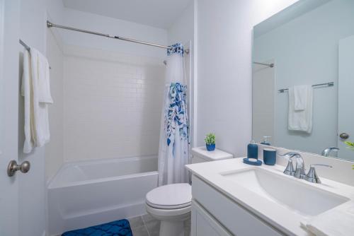 a white bathroom with a toilet and a sink at Amazing Home in Ocala in Ocala
