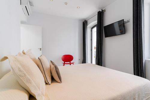 a bedroom with a bed with pillows and a television at Arena House Conil in Conil de la Frontera