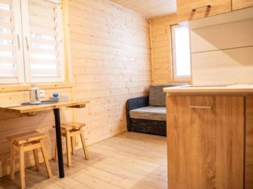 a small kitchen with a bench in a tiny house at OLIWIER domki letniskowe Okuninka in Okuninka