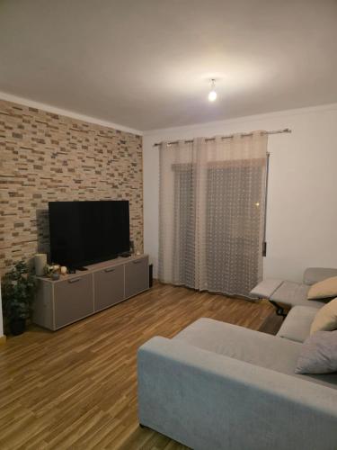 a living room with a couch and a flat screen tv at MM Apartamento com Quarto privado Com árias in Coimbra