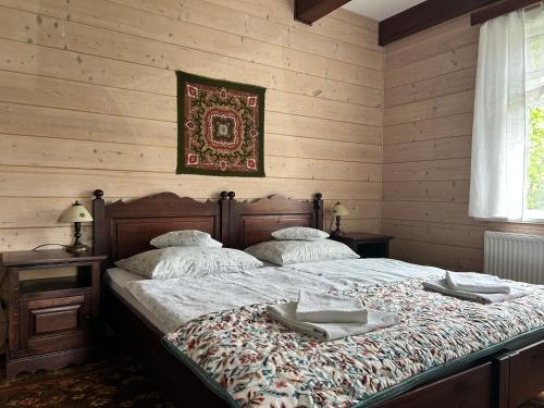 a bedroom with a bed with two towels on it at Leśne PoBudki in Białowieża