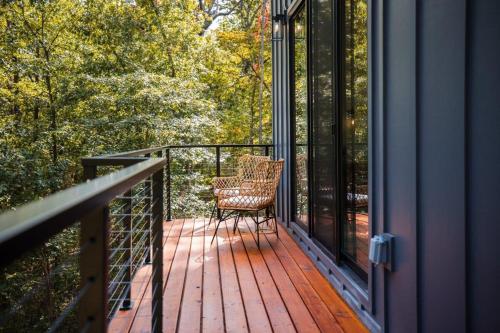 a chair sitting on the deck of a house at Lookout Chalet NEW Build huge Party Deck Hot Tub and Trail Access in Bella Vista