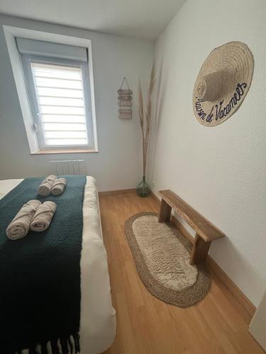 a bedroom with a bed with a bench and a window at Le Cocon de KENNA au centre du bourg in Dompierre-sur-Besbre