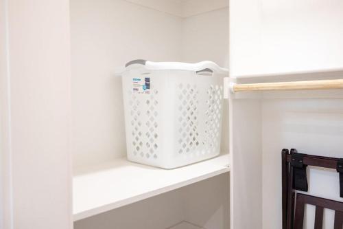 a white laundry basket sitting on a shelf in a kitchen at Lookout Chalet NEW Build huge Party Deck Hot Tub and Trail Access in Bella Vista