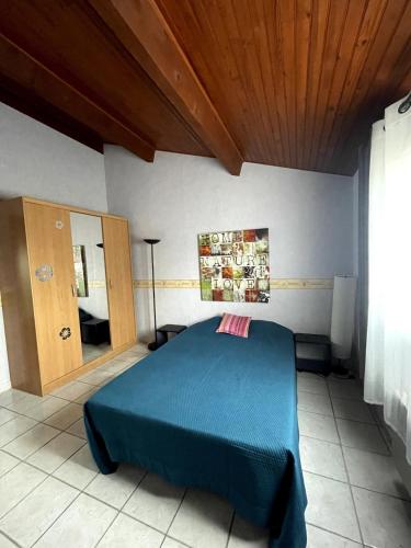 une chambre avec un lit bleu et un miroir dans l'établissement Maison de vacances avec piscine, à Baillargues