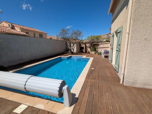 une piscine dans l'arrière-cour d'une maison dans l'établissement Maison de vacances avec piscine, à Baillargues