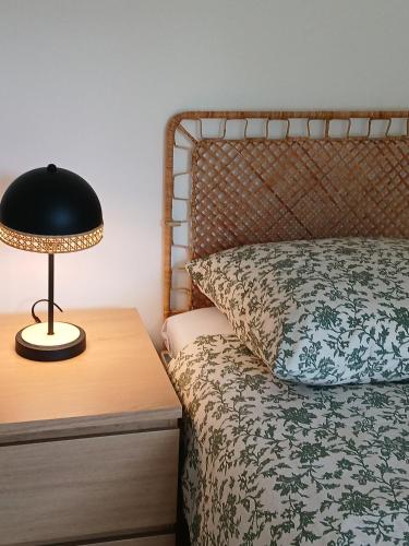 a bedroom with a bed and a lamp on a table at Zapach lasu Karwica Naturalne SPA, sauna, joga A206 in Karwica