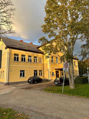 a yellow building with cars parked in front of it at NEW Cozy design studio near the river in Salacgrīva