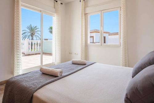 a bedroom with a bed with two towels on it at Villa Dalia by Villa Plus in Beniarbeig