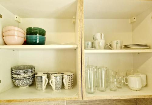 a cupboard filled with lots of glasses and plates at Holiday Apartment near Triberg Waterfall in Triberg
