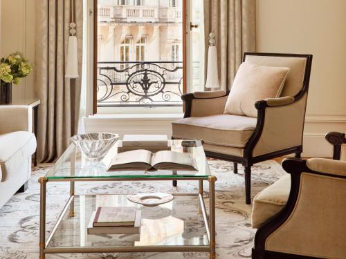 a living room with a glass coffee table and a chair at The Woodward - Auberge Collection in Geneva