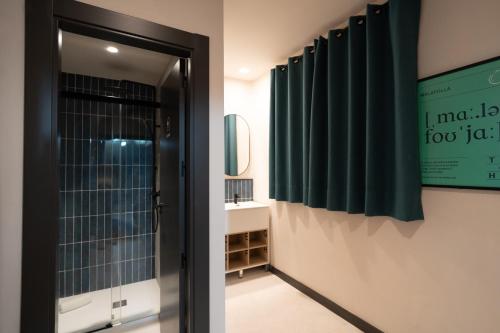 a bathroom with a green shower curtain and a mirror at The Central House Granada Elvira in Granada