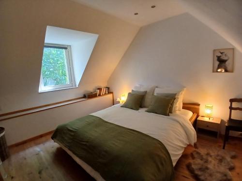 Un dormitorio con una cama grande en un ático. en Le Petit Briacin, en Saint-Briac-sur-Mer