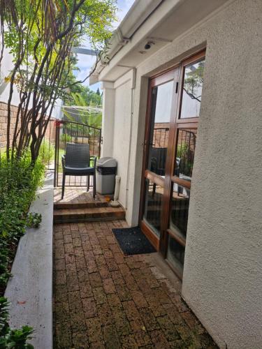 a door to a house with a chair next to it at Mountain Rose Cottage in Bellville