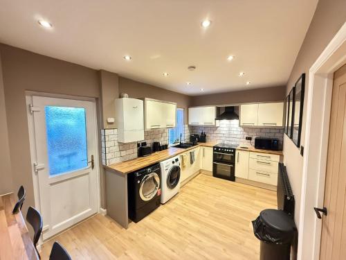 a large kitchen with a washer and dryer in it at Modern House Maryport Sleeps 6 in Maryport