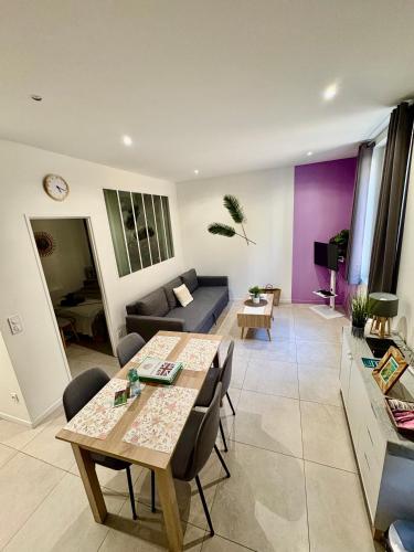 un salon avec une table et un canapé dans l'établissement Escapades L'Isloises au cœur de L'Isle-sur-la-Sorgue., à LʼIsle-sur-la-Sorgue