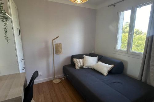 un canapé bleu dans une pièce avec une fenêtre dans l'établissement Apartment with terrace in Roquebrune-sur-Argens, aux Issambres