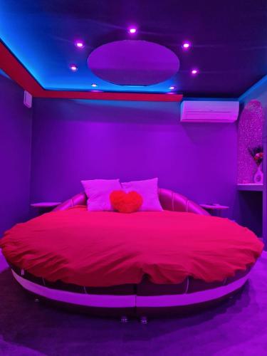 a bedroom with a large bed with purple lights at Secret Night Pamiers in Pamiers