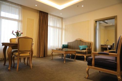 a living room with a table and a couch at La Roche Hotel in Erbil
