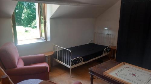 une chambre avec un lit, un canapé et une chaise dans l'établissement Ferme La Petite Verte, à Saint-Pierre-de-Frugie